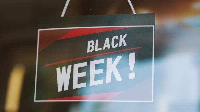 Black Week Sale sign hanging on the door in 4K Slow motion 60fps