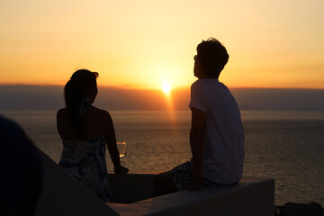 A couple watching a sunset. Santorini, Oia, Greece.