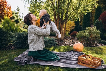 Mother with her little son having picnic on a back yard