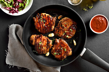 Fried pork steaks in frying pan