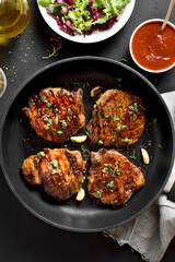 Fried pork steaks in frying pan