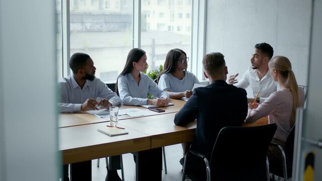 Corporate discussion of new project, young middle eastern boss communicating with partners in office
