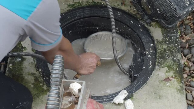 Drain Cleaning. Plumber Repairing Clogged Grease Trap With Auger Machine. Maintenance The Sewage System And Grease Trap By Professional Plumber. Using Auger Snake To Fix And Unclog A Drain.