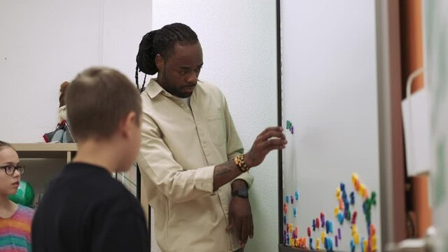 An African American teacher teaches a child using a magnetic board in the classroom.School for Children, Teaching Adolescents, Gain Knowledge, Learn the Language.
