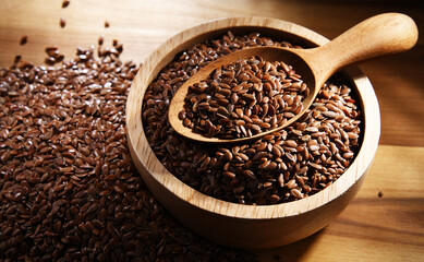 Bowl of brown flax seeds on wooden table