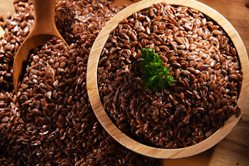 Bowl of brown flax seeds on wooden table