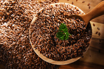 Bowl of brown flax seeds on wooden table