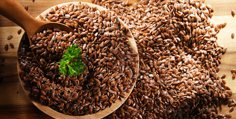 Bowl of brown flax seeds on wooden table