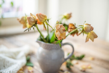 Blumenstrauss aus vertrockneten Rosen in Keramik Krug
