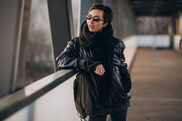 Fototapeta na wymiar Woman in black jacket walking through the bridge
