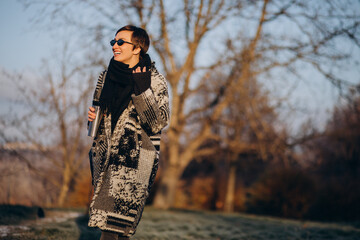 Young woman drinking coffee in the morning and walking in park