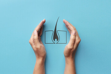 The silhouette of a human hair in human hands. A symbol of the treatment and prevention of diseases of the hair and scalp