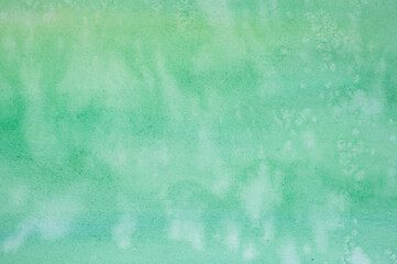 green watercolor with white spots. painted textured paper with watercolor paints of different green color. background or backdrop of abstract art handmade diy painting