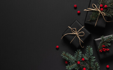 Wrapped gifts with red berries and branches of Christmas tree. Flat lay, top view with copy space...