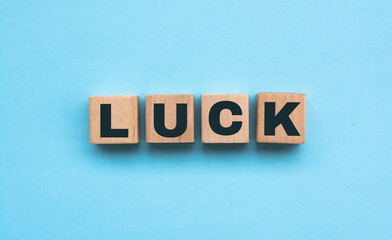 the word luck is written on a wooden cubes structure. blocks on a blue background. financial concept. selective focus.