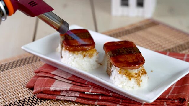 Spam musubi is a popular snack and lunch food in Japan that composed of spam on top of rice wrapped with thick or thin nori