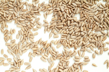 Peeled (dehulled) sunflower seeds on white background.