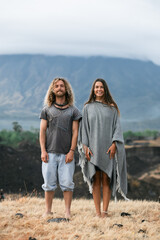 A beautiful, stylish couple lies on the grass and enjoys the moment, against the backdrop of the mountains.