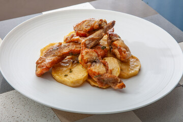 Conejo con patatas al horno. Rabbit with baked potatoes.