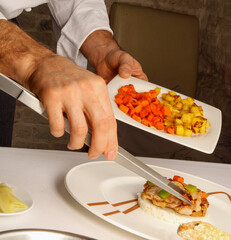 Manos de chef haciendo un aperitivo de solomillo con verduras. Chef hands making a sirloin appetizer with vegetables.