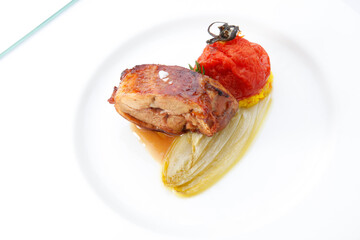 Cochinillo asado con endivias y tomate asado. Roast suckling pig with endives and roasted tomato