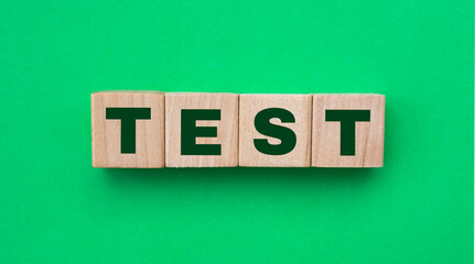 The word test on wooden cubes on a table, on a green background.