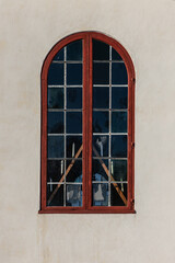 Red vaulted window on a white stone wall