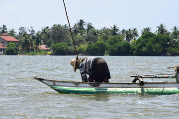 Fisherman is capturing fish harvest on the lake 