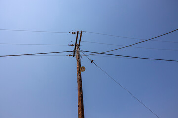 Beautiful view of old power line on blue sky background. Greece. 