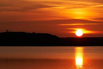 Colourful sunset at lake Flyndersoe in Denmark with the sky reflecting in the lake on a silent evening