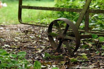 close up of the wheel of an old metal gate, pushed half way open