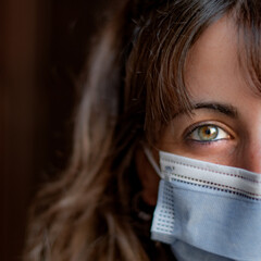 Girl with blue mask and green eyes smiling under mask