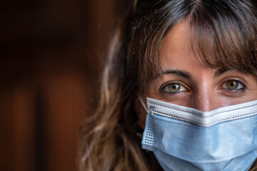 Girl with blue mask and green eyes smiling under mask