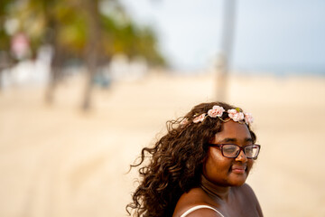 Photo of a beautiful young mixed race female posing in a abstract pattern dress on the beach