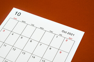 October 2021 calendar sheet on red background.