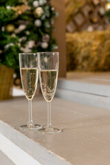 Two glasses of champagne with lights on the background. very shallow depth of field, selective focus. Winter holidays. Christmas, Happy new year drinks.