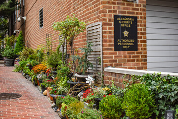 Fototapeta na wymiar Alexandria, Virginia, USA - October 8, 2021: Garden in an Alleyway Next to the Garage Opening of the Alexandria Sheriff’s Office in Old Town Alexandria