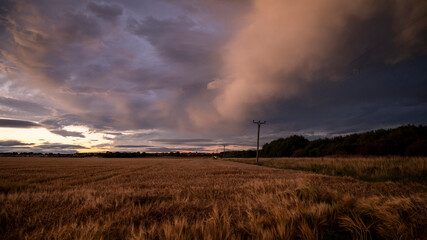 Fototapeta na wymiar Storm over the field with Lossiemouth distant