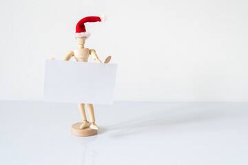 Christmas blank greeting card mock-up scene. Wooden mannequin posing on greeting card or gift list...