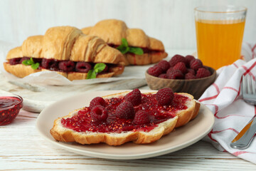 Concept of delicious food with croissants with raspberry jam on white wooden background