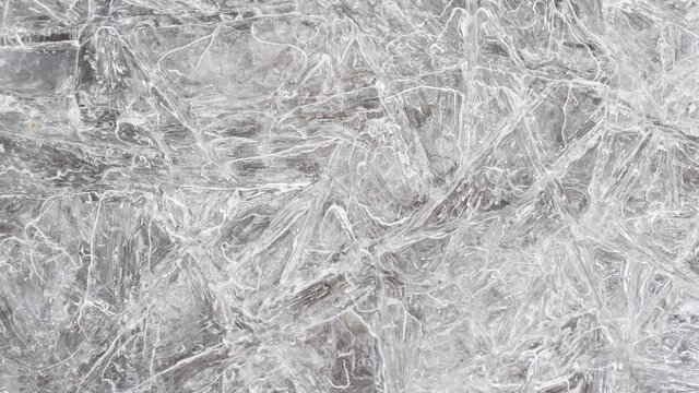 cracked ice texture on the surface, slow motion close-up, natural clean background. Frozen water texture