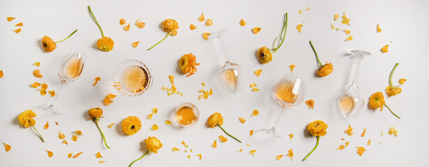Flat-lay of trendy Orange or Amber wine and yellow flowers