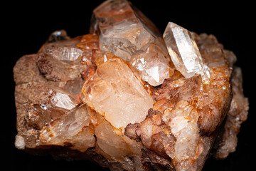 Natural Quartz crystal cluster on black background, selective focus. Pure crystalline mineral. Extremely hard and sharp rock found in river. Macro close up of glassy smoky brown orange Quartz crystal.