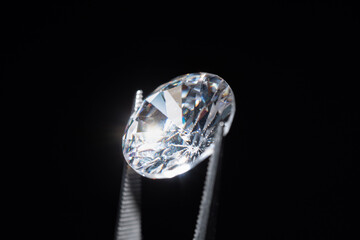 Loose diamond in tweezers selective focus. Macro shot of precious stone inspection for defects....