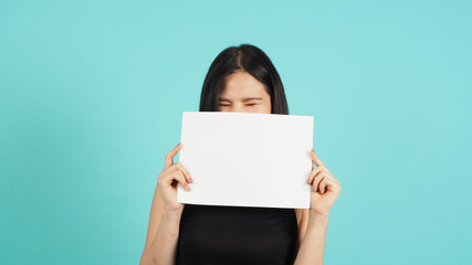 Blank empty paper in asian woman's hand on mint green or Tiffany Blue background.