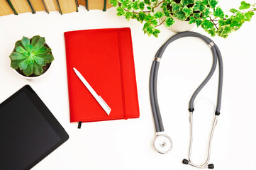 stethoscope notepad and flowers on a white background