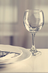 Wine glass and plates with cutlery, vertical, no people, serving, toned, selective focus, 