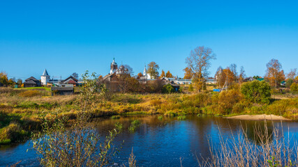 Naklejka na ściany i meble Autumn landscape with an ancient monastery in the background.