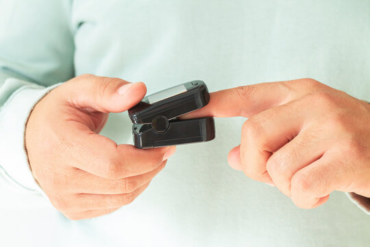 Senior man check oxygen saturation with oximeter