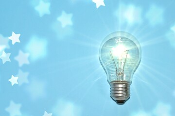 shining light bulb with stars on blue background